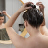 young woman applying anti dandruff product 1 Lara Sense